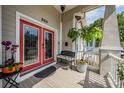 Covered porch with tile floor, red glass door, bench, and attractive plants at 260 Sw Lincoln N Cir, St Petersburg, FL 33703