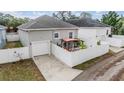 Rear view of the home featuring a white fence, patio area, and two-car garage at 260 Sw Lincoln N Cir, St Petersburg, FL 33703