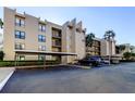 Condominium building featuring covered parking, balconies, and a well-maintained exterior at 2614 Cove Cay Dr # 409, Clearwater, FL 33760