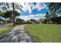 Spacious property featuring a lush green lawn and a long, private driveway at 2679 Haines Bayshore Rd, Clearwater, FL 33760