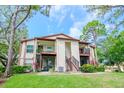 Well-maintained condo building with balconies, lush landscaping, and well-kept green lawn at 3455 Countryside Blvd # 31, Clearwater, FL 33761