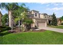 Two-story home showcasing stone accents, lush greenery, and a convenient two-car garage at 4407 Scarlet Loop, Wesley Chapel, FL 33544