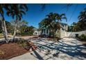 Exterior home showcasing mature palm trees, brick driveway, and fenced yard at 451 27Th N Ave, St Petersburg, FL 33704