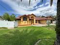 Charming single-story home with yellow facade, red accents, well-maintained lawn, and a white picket fence at 4593 Goldcoast Ave, Spring Hill, FL 34609
