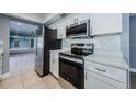 Well-equipped kitchen with stainless steel appliances, white cabinets, and sleek countertops at 4704 Shale Pl, Tampa, FL 33615