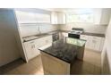 Modern kitchen featuring granite countertops, white cabinetry and a kitchen island at 5122 Dove Dr, New Port Richey, FL 34652