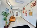 The hallway features neutral tiling, artwork, an elevator and a sitting area with a leather couch at 701 S Madison Ave # 414, Clearwater, FL 33756