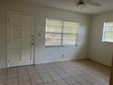 Bright bedroom featuring tile flooring, neutral walls, and ample natural light from two windows at 7401 N Albany Ave, Tampa, FL 33604