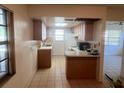 Cozy kitchen featuring tile floors, wood cabinets, and plenty of counter space at 7401 N Albany Ave, Tampa, FL 33604