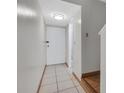 Condo hallway with tile floors and neutral paint, showcasing entry door and staircase at 7505 Pitch Pine Cir # 122, Tampa, FL 33617