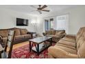 Inviting living room featuring plush sofas, a ceiling fan, and sliding glass doors for natural light at 7505 Pitch Pine Cir # 122, Tampa, FL 33617