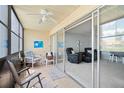 Enclosed condo patio with tile flooring, fan, and sliding glass doors leading to the spacious living room at 7701 Starkey Rd # 443, Seminole, FL 33777