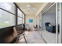 Enclosed condo patio with tile flooring, fan, and sliding glass doors leading to the spacious living room at 7701 Starkey Rd # 443, Seminole, FL 33777