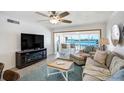 Living room with waterfront views, cozy seating, ceiling fan, and modern entertainment center at 865 S Gulfview Blvd # 308, Clearwater, FL 33767