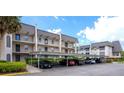 Exterior of the building with covered parking for residents and a neatly maintained landscape at 8703 Bardmoor Blvd # 305, Seminole, FL 33777
