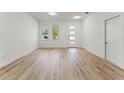 Bright living room with wood flooring, white walls, and natural light through large windows at 8906 N Otis Ave, Tampa, FL 33604
