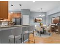Open-concept dining area featuring hardwood floors, stylish lighting, and a breakfast bar with modern stools at 1051 Andrew Aviles Cir, Tampa, FL 33619