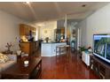 Bright, open-concept living space with hardwood floors, adjacent to a modern kitchen and breakfast bar at 11227 Summer Star Dr, Riverview, FL 33579