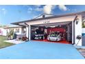 Garage with two sports cars and red epoxy floors at 1438 S Hillcrest Ave, Clearwater, FL 33756