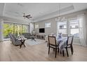 Bright living and dining area featuring hardwood floors, a ceiling fan, and sliding glass doors to the backyard at 15170 Aviles Pkwy, Odessa, FL 33556