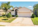 Lovely single-story home boasting a manicured lawn, mature palm, and a two-car garage at 16616 Magnolia Reserve Pl, Wimauma, FL 33598