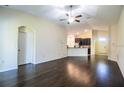 Open-concept living room showcases hardwood floors and seamless flow into the kitchen at 16616 Magnolia Reserve Pl, Wimauma, FL 33598