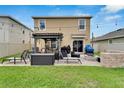 Private backyard with a pergola, outdoor seating, and a cozy fire pit area at 16815 Trite Bend St, Wimauma, FL 33598