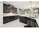 Modern kitchen features dark wood cabinets, stainless steel appliances, and white countertops at 1796 Tonka Ter, Wesley Chapel, FL 33543