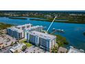 Aerial view of waterfront condos with boat docks along bay, showcasing its coastal community at 19519 Gulf Blvd # 203, Indian Shores, FL 33785