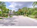 Community entrance featuring an ornate gate, lush landscaping, and a secure, private setting at 2746 Birchcreek Dr, Wesley Chapel, FL 33544