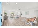 Bright living room with wood-look floors, neutral decor, and sliding glass doors for easy outdoor access at 2901 Forestwood Dr, Seffner, FL 33584