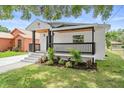 Lovely front yard view of a renovated home with modern colors, manicured landscaping, and inviting porch at 3215 E Powhatan Ave, Tampa, FL 33610
