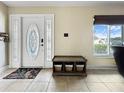 Bright entryway with tile flooring, decorative rug, ample natural light, and bench at 3508 Yale Cir, Riverview, FL 33578
