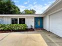 Welcoming entrance with blue door, manicured landscaping, and attached two car garage at 3508 Yale Cir, Riverview, FL 33578