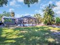 Expansive backyard featuring a screened-in pool enclosure with palm trees, perfect for outdoor entertainment at 37 W Boyer St, Tarpon Springs, FL 34689