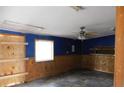 View of unfinished room, blue painted walls, wood trim, and ceiling fan at 3940 E Knights Griffin Rd, Plant City, FL 33565