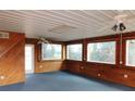 Bright sunroom featuring wood paneling, large windows, and two ceiling fans at 3940 E Knights Griffin Rd, Plant City, FL 33565