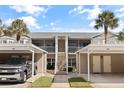 View of the building exterior with covered parking and screened in patios at 402 Laurel Lake Dr # 104, Venice, FL 34292