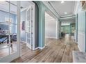 Elegant foyer with wood-look tile flooring, open archways, and views into the office and dining area at 4094 Windcrest Dr, Wesley Chapel, FL 33544