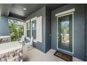 Inviting front porch with stone accents, white chairs, and a decorative glass front door at 4094 Windcrest Dr, Wesley Chapel, FL 33544