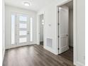 Bright foyer featuring a white door with windows, hardwood floors, and fresh, white walls at 4260 Baudelaire Ct, Brooksville, FL 34604