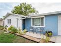 Welcoming blue exterior features a cozy seating area and meticulous landscaping. A great place to relax at 4545 Annette St, New Port Richey, FL 34652