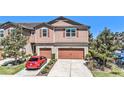 Charming two-story townhome with a double car garage and beautifully landscaped front yard at 5005 Blue Latan Ln, Tampa, FL 33610