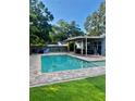 Inviting backyard oasis with a sparkling pool, comfortable seating, and a covered patio area at 5645 97Th N Way, St Petersburg, FL 33708