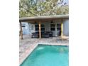Covered poolside patio with comfortable seating and ceiling fans for relaxing outdoor living at 5645 97Th N Way, St Petersburg, FL 33708