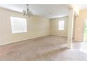 Spacious living room with neutral carpet, chandelier lighting, and bright natural light at 621 Washita Stone Dr, Ruskin, FL 33570