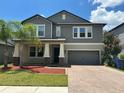 Beautiful two-story home featuring a two-car garage, palm tree, and brick paver driveway at 6244 English Hollow Rd, Tampa, FL 33647