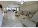 Spacious living area with a kitchen view, featuring tile floors and comfortable seating at 6244 English Hollow Rd, Tampa, FL 33647