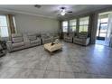 Bright living room with tile flooring, large windows, and comfortable leather seating at 6244 English Hollow Rd, Tampa, FL 33647