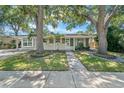 Inviting single-story home with a well-maintained lawn, mature trees, and a classic design at 6307 S Cameron Ave, Tampa, FL 33616